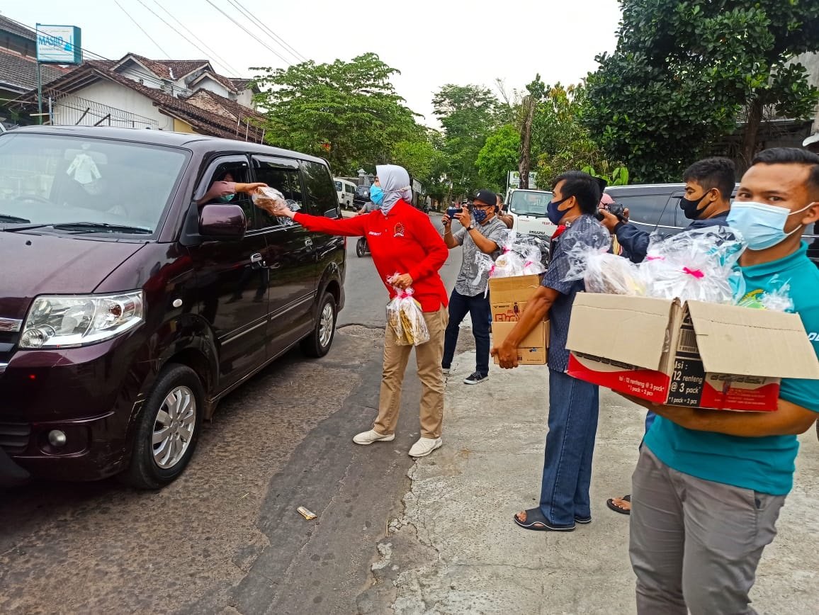 BAGIKAN. Anggota DPD RI Denty Widi Eka Pratiwi bersama relawan membagikan produk UMKM kepada pengendara di perempatan Geneng Temanggung, Jumat (7/5). (foto:setyo wuwuh/temanggung ekspres)