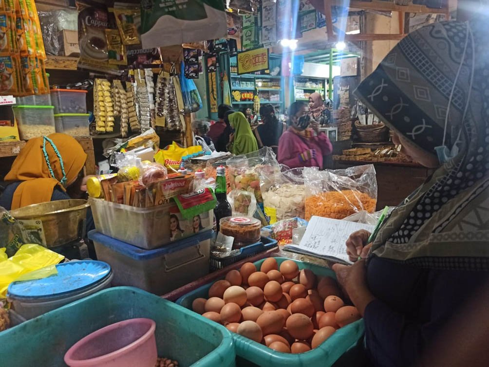 MELAYANI. Salah seorang pedagang Pasar Kliwon Rejo Amertani Temanggung sedang melayani pembeli.(Foto setyo wuwuh/Temanggung Ekspres)