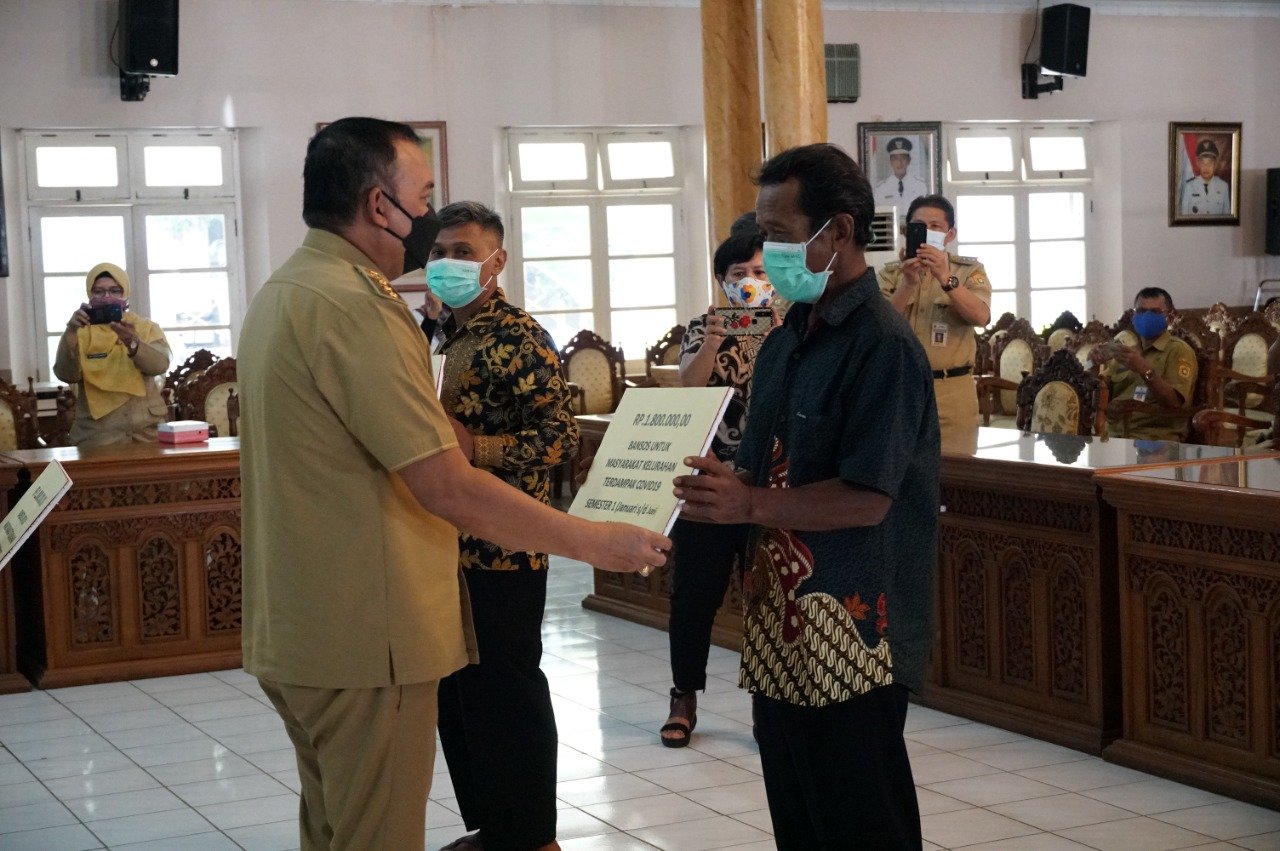 BANSOS. Salah satu perwakilan warga menerima bansos dari Pemkab Purworejo secara simbolis akibat diberlakukannya PPKM Darurat Level 4 di Purworejo. (Foto lukman)