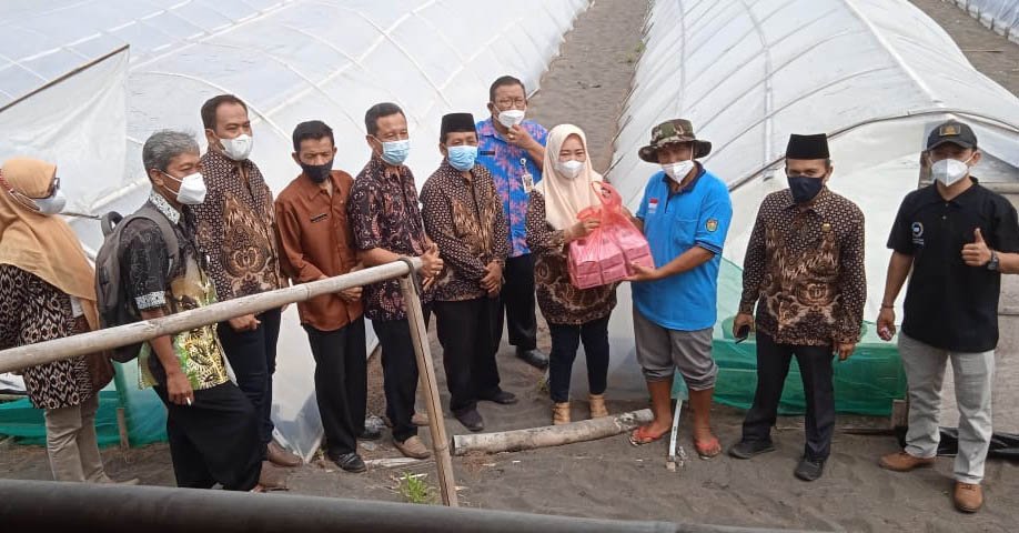 SERAHKAN. Ketua Komisi III menyerahkan bantuan masker kepada para petani garam. (Foto lukman)
