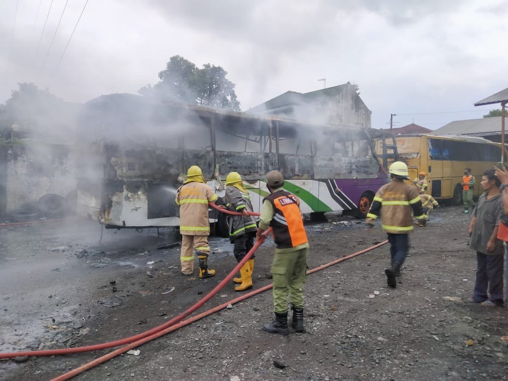 PEMADAMAN. Tin Damkar, Linmas, dan Satpol PP melakukan pemadaman bus yang terbakar di Jalan Soekarno Hatta Kota Magelang, kemarin. (foto : IST/magelang ekspres)
