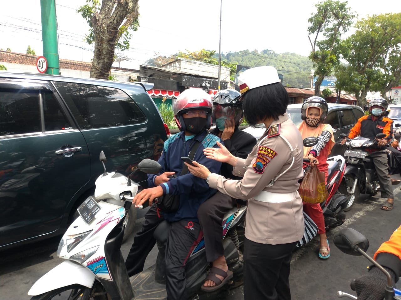 SOSIALISASI. Jajaran polisi Polres Magelang Kota mensosialisasikam aplikasi Peduli Lindungi kepada pengguna jalan yang melintas, Sabtu (4/9).