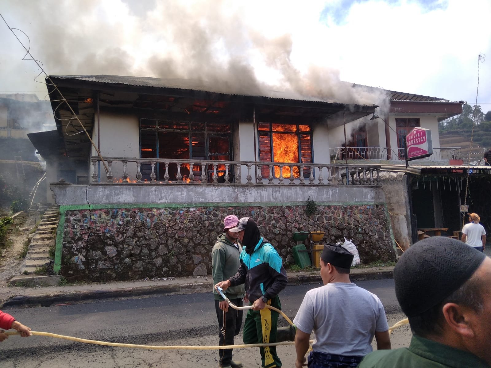 EVAKUASI. Masyarakat di Dieng Wetan saat melakukan evakuasi pada rumah yang sudah dalam kondisi terbakar hebat.