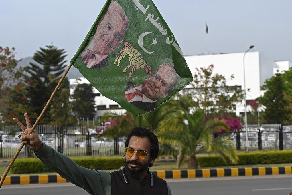 Warga Pakistan mengibarkan bendera bergambar Shehbaz Sharif.-AFP-