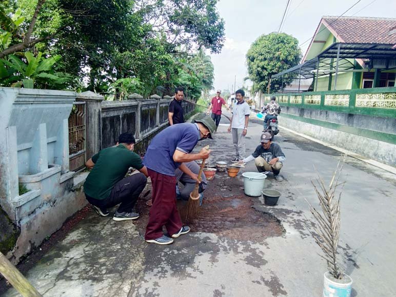 TAMBAL JALAN. Warga Desa Sukorejo Kecamatan Mertoyudan Magelang bergotong royong menambal jalan berlubang.