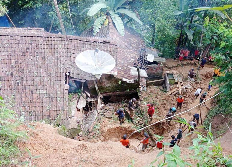 BERSIHKAN TANAH. BPBD Purworejo dibantu warga sekitar membersihkan longsoran tanah yang menimpa sebuah rumah milik warga Desa Ngaran Kecamatan Kaligesing, kemarin.(Foto: eko)