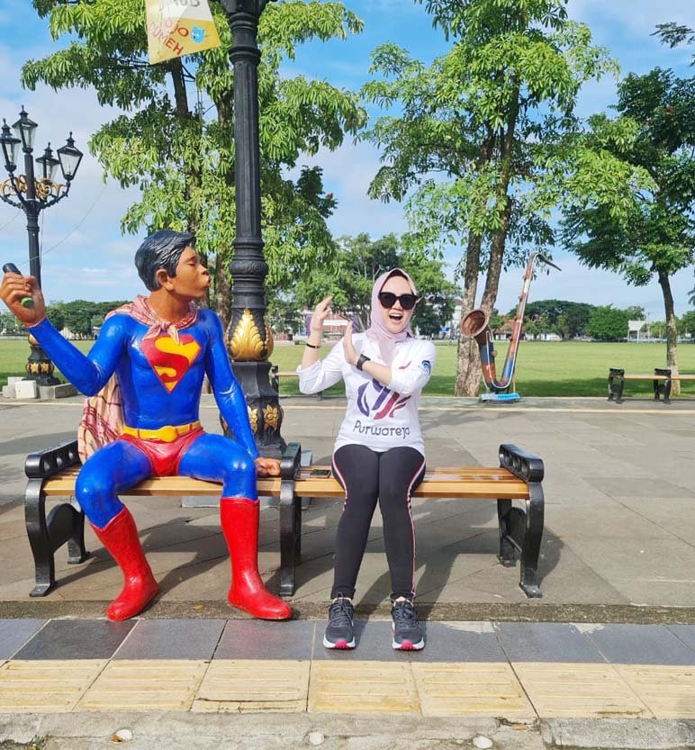 BERFOTO. Pengunjung Alun-alun Purworejo saat berfoto di samping patung karikatur karakter superhero. (foto: lukman hakim/purworejo ekspres)