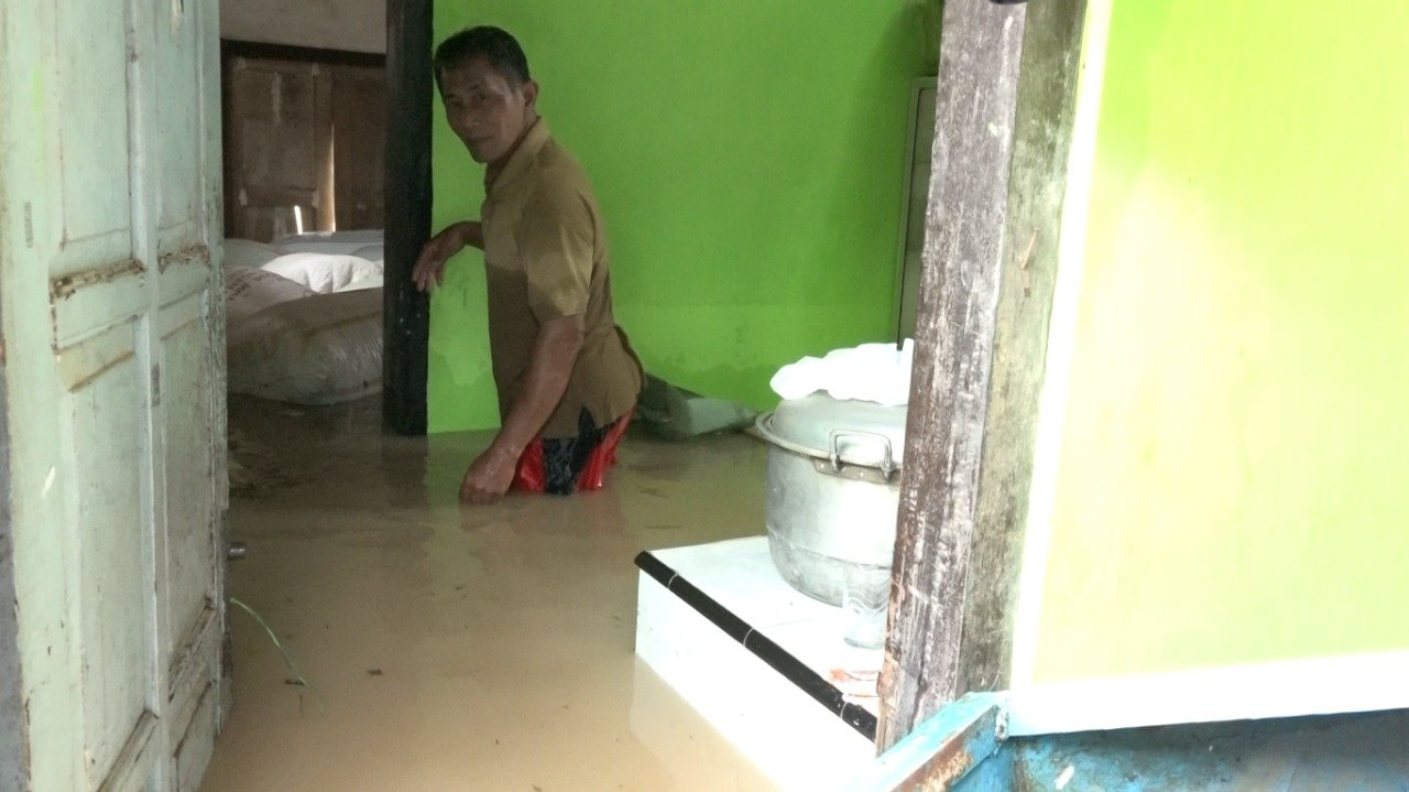 DIKEPUNG BANJIR. Pelaku usaha kacang kulit harus menanggung kerugian puluhan juta karena tak dapat menyelamatkan produk saat banjir mengepung rumahnya di Desa Tangkisan Kecamatan Bayan, kemarin.(Foto: eko)